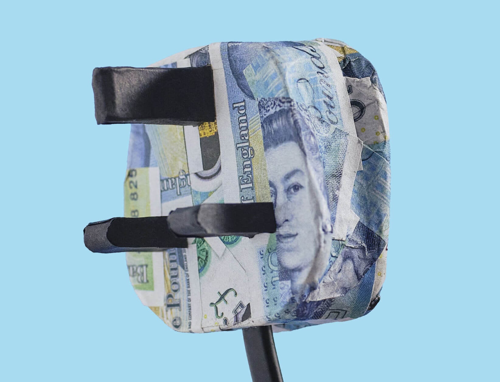 close up of a three pin plug that has been decoupaged with five pound notes