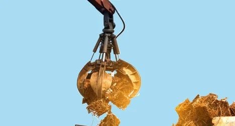 Digger picks up recycled metals against a bright blue background.